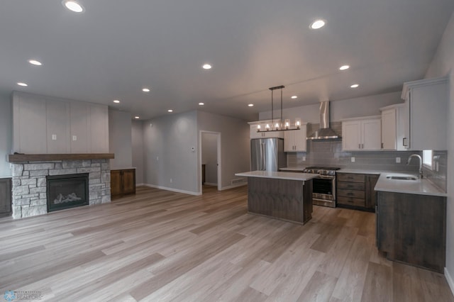 4174 Arthur Dr S, Fargo, ND 58104 - kitchen featuring appliances with stainless steel finishes, wall chimney exhaust hood, a center island, open floor plan, and a sink