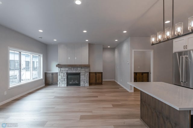 4174 Arthur Dr S, Fargo, ND 58104 - unfurnished living room with recessed lighting, light wood finished floors, baseboards, and a stone fireplace
