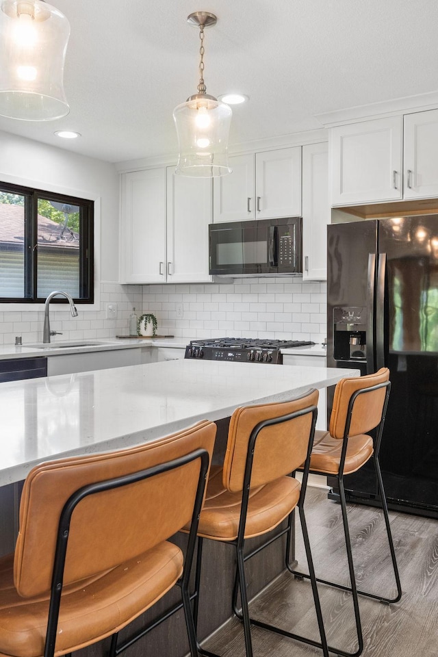 9645 Garrison Way, Eden Prairie, MN 55347 - kitchen featuring black appliances, light countertops, white cabinetry, and decorative backsplash