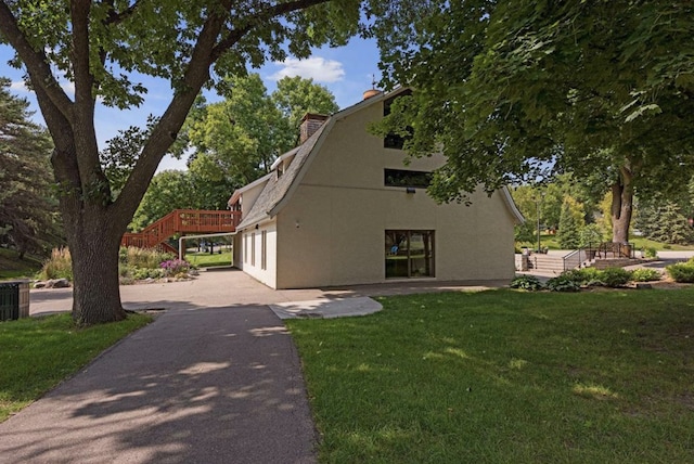 9645 Garrison Way, Eden Prairie, MN 55347 - view of property exterior with a yard, stairway, driveway, stucco siding, and a chimney