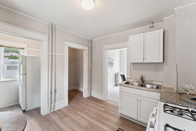 1404 Russell Ave N, Minneapolis, MN 55411 - kitchen featuring white appliances, a sink, white cabinets, a textured ceiling, and light wood-style floors