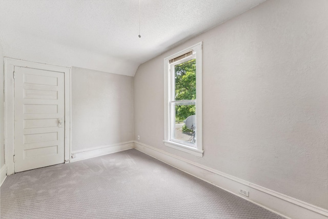 1404 Russell Ave N, Minneapolis, MN 55411 - spare room with carpet, vaulted ceiling, a textured ceiling, baseboards, and a textured wall