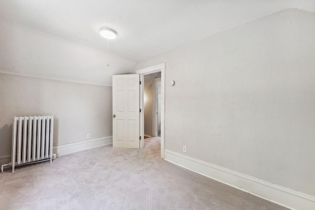 1404 Russell Ave N, Minneapolis, MN 55411 - carpeted empty room featuring radiator heating unit, lofted ceiling, and baseboards