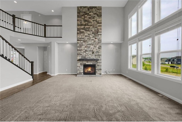 6919 156th St, Savage, MN 55378 - unfurnished living room with a high ceiling, carpet, stairway, a stone fireplace, and recessed lighting