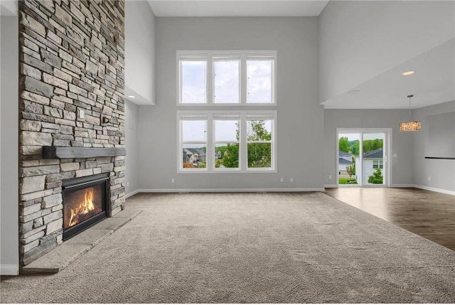 6919 156th St, Savage, MN 55378 - unfurnished living room featuring carpet, a towering ceiling, and a fireplace