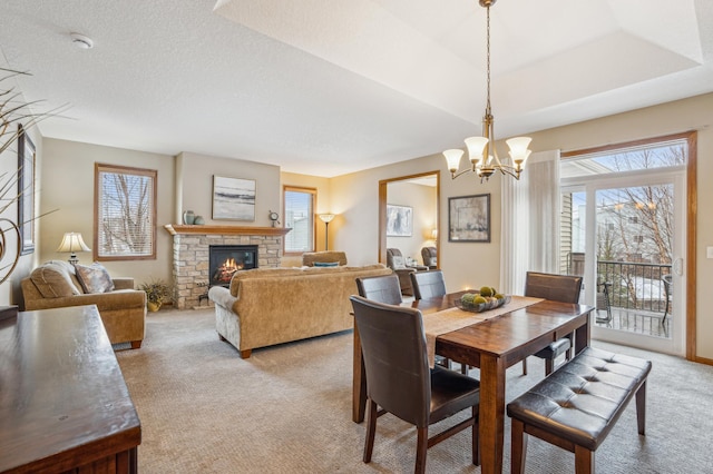 8634 Corbin Ct, Inver Grove Heights, MN 55076 - dining area featuring light carpet, a chandelier, and a fireplace