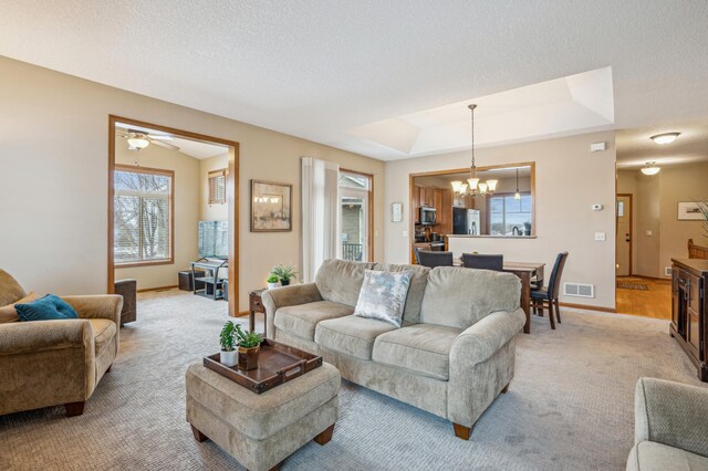 8634 Corbin Ct, Inver Grove Heights, MN 55076 - living area featuring a chandelier, light colored carpet, baseboards, and a raised ceiling