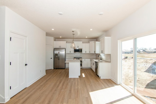 914 Milborne Ln NW, Rochester, MN 55901 - kitchen with stainless steel appliances, a center island, light countertops, tasteful backsplash, and light wood finished floors