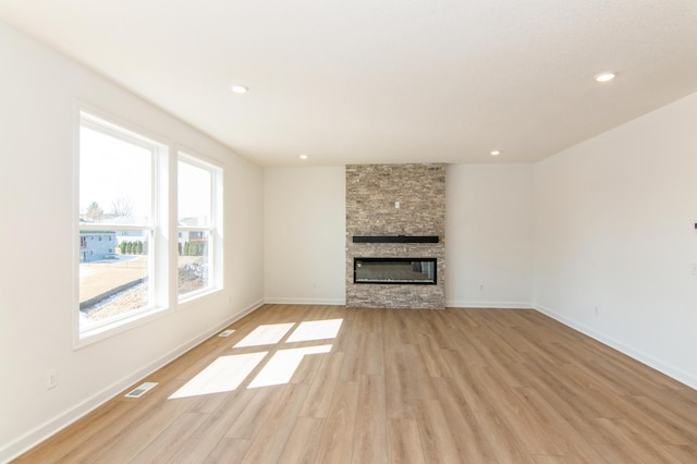 914 Milborne Ln NW, Rochester, MN 55901 - unfurnished living room featuring light wood-type flooring, a stone fireplace, baseboards, and recessed lighting