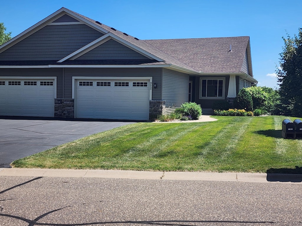 8650 Corbin Ct, Inver Grove Heights, MN 55076 - view of front of house with a front lawn, stone siding, and driveway