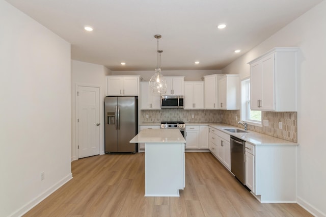 2033 Hadley Hills Dr NE, Rochester, MN 55906 - kitchen featuring stainless steel appliances, a sink, light wood-style floors, tasteful backsplash, and light countertops