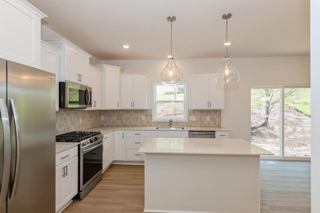 2033 Hadley Hills Dr NE, Rochester, MN 55906 - kitchen with stainless steel appliances, a sink, light countertops, backsplash, and recessed lighting