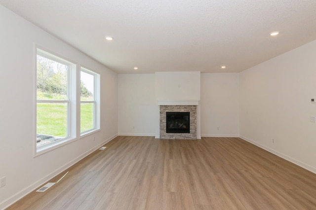 2033 Hadley Hills Dr NE, Rochester, MN 55906 - unfurnished living room featuring light wood-style floors, baseboards, a stone fireplace, and recessed lighting