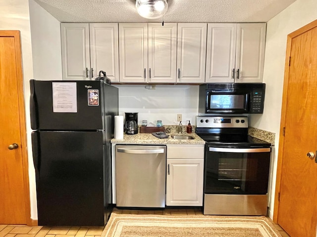 128 Bridge Run Ln Unit B, Lutsen Twp, MN 55612 - kitchen featuring black appliances, white cabinetry, a sink, and a textured ceiling