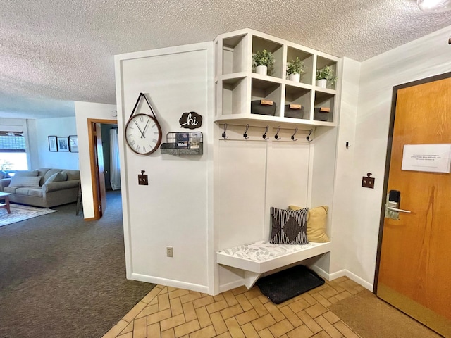 128 Bridge Run Ln Unit B, Lutsen Twp, MN 55612 - mudroom featuring a textured ceiling, baseboards, brick patterned floors, and carpet floors