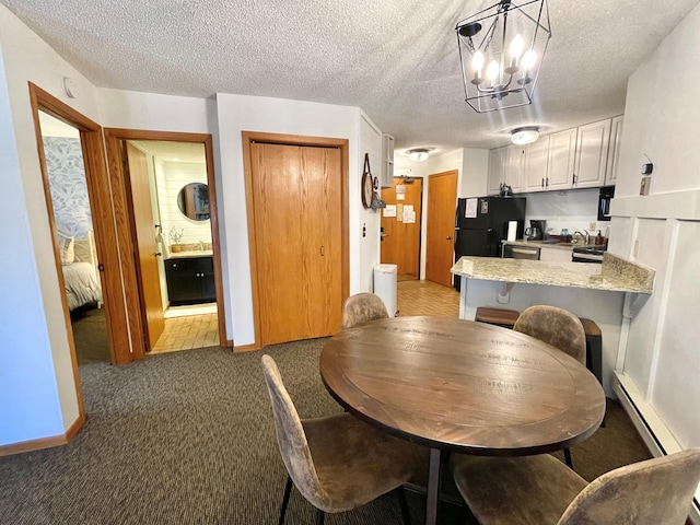 128 Bridge Run Ln Unit B, Lutsen Twp, MN 55612 - dining space with light colored carpet, a textured ceiling, a baseboard radiator, a chandelier, and baseboards