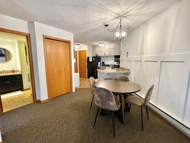 128 Bridge Run Ln Unit B, Lutsen Twp, MN 55612 - dining area featuring carpet floors, a baseboard radiator, and a chandelier