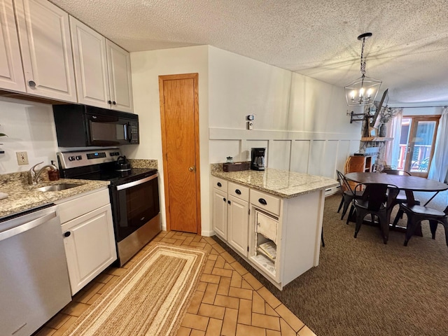 128 Bridge Run Ln Unit B, Lutsen Twp, MN 55612 - kitchen with appliances with stainless steel finishes, white cabinetry, a sink, a chandelier, and a peninsula