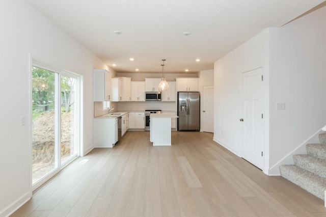 5051 52nd Ave NW, Rochester, MN 55901 - kitchen with stainless steel appliances, a sink, light countertops, light wood-style flooring, and white cabinets