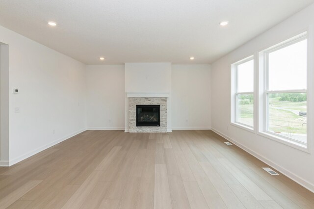 5051 52nd Ave NW, Rochester, MN 55901 - unfurnished living room with light wood-style flooring, a fireplace, baseboards, and recessed lighting