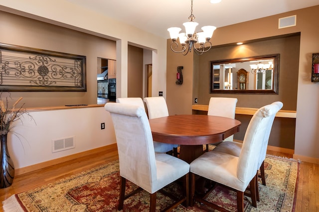 1120 Southridge Rd, New Ulm, MN 56073 - dining room featuring a chandelier, wood finished floors, and baseboards