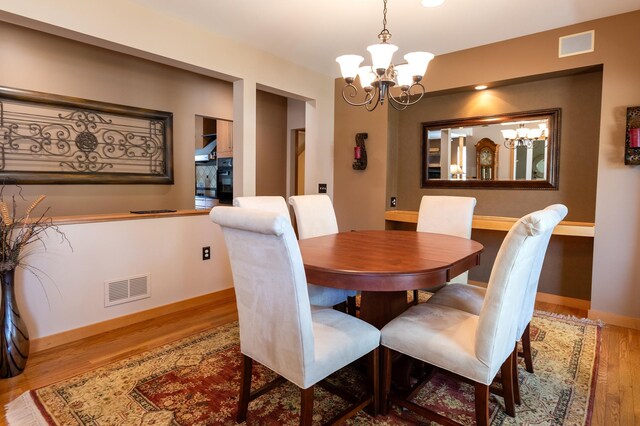 1120 Southridge Rd, New Ulm, MN 56073 - dining room featuring a chandelier, wood finished floors, and baseboards