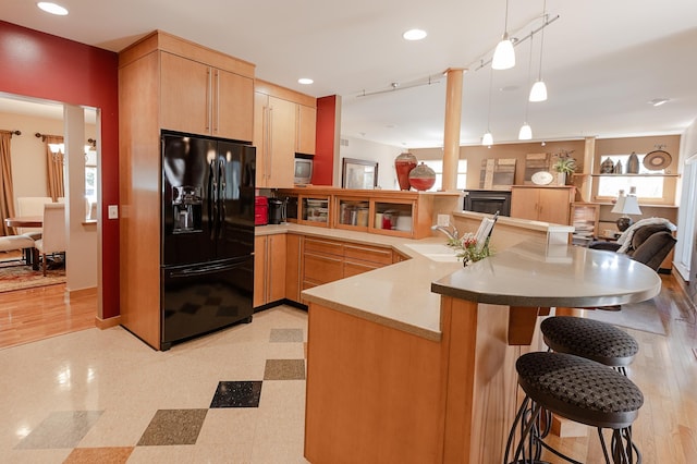 1120 Southridge Rd, New Ulm, MN 56073 - kitchen with black fridge with ice dispenser, light brown cabinets, a peninsula, a sink, and stainless steel microwave
