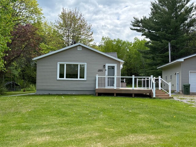 11966 Lindquist Rd, Hibbing, MN 55746 - back of house with a wooden deck, a yard, and a garage