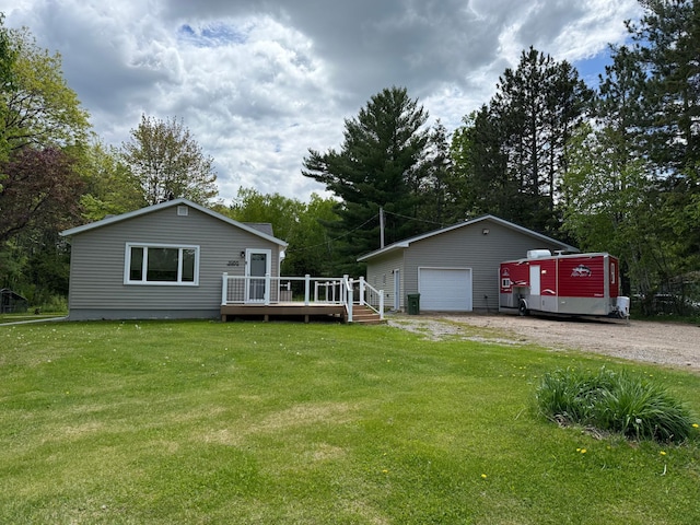 11966 Lindquist Rd, Hibbing, MN 55746 - view of grassy yard with a wooden deck, a garage, an outbuilding, dirt driveway, and view of scattered trees