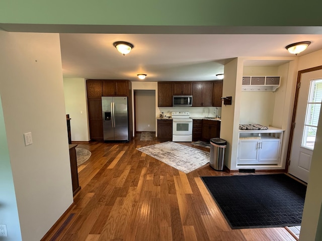 11966 Lindquist Rd, Hibbing, MN 55746 - kitchen with stainless steel appliances, dark wood-style flooring, dark brown cabinets, light countertops, and a sink