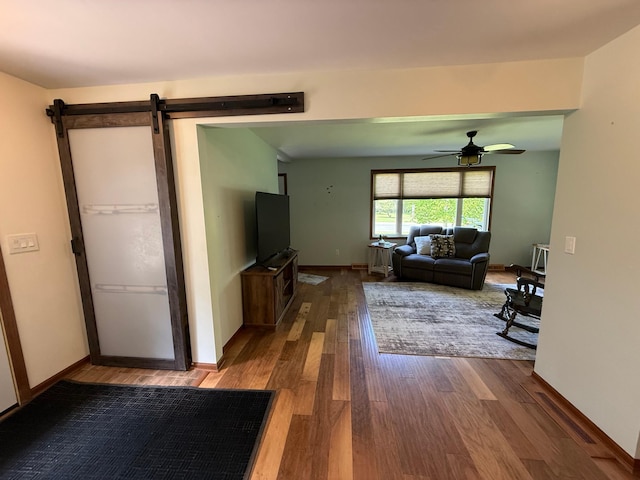 11966 Lindquist Rd, Hibbing, MN 55746 - living room with dark wood finished floors, a ceiling fan, a barn door, and baseboards