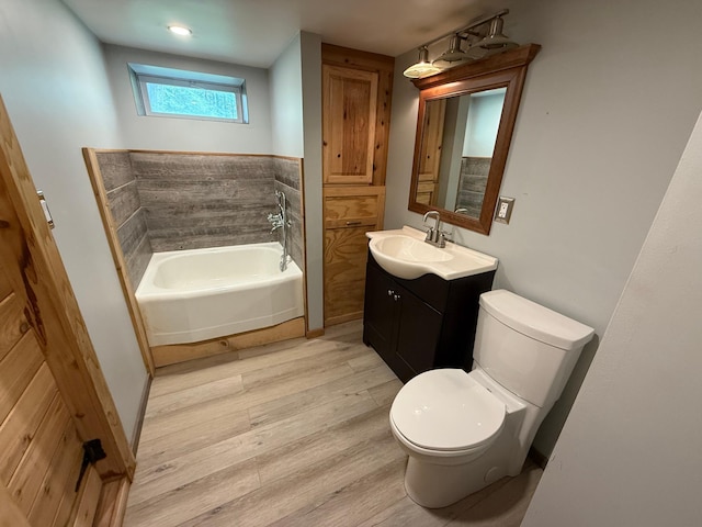 11966 Lindquist Rd, Hibbing, MN 55746 - bathroom featuring wood finished floors, toilet, a garden tub, and vanity