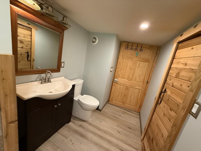 11966 Lindquist Rd, Hibbing, MN 55746 - bathroom featuring vanity, wood finished floors, and toilet