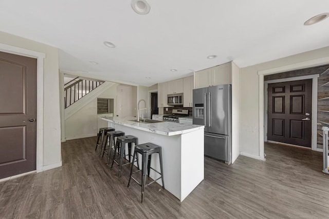 517 1st Ave NW, Winnebago, MN 56098 - kitchen with stainless steel appliances, a sink, a kitchen island with sink, baseboards, and dark wood-style flooring