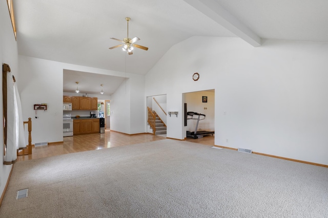 8187 230th St E, Faribault, MN 55021 - unfurnished living room with light carpet, stairs, a ceiling fan, high vaulted ceiling, and baseboards