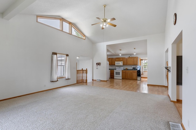 8187 230th St E, Faribault, MN 55021 - unfurnished living room featuring light colored carpet, a ceiling fan, high vaulted ceiling, and baseboards