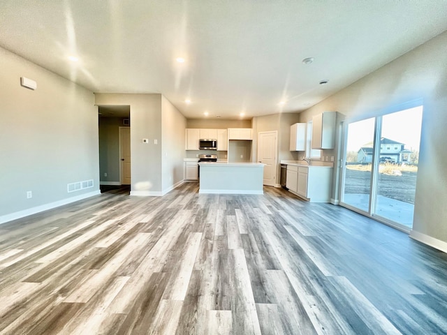1025 Shoreview Dr, Jordan, MN 55352 - unfurnished living room with light wood finished floors, baseboards, a sink, and recessed lighting