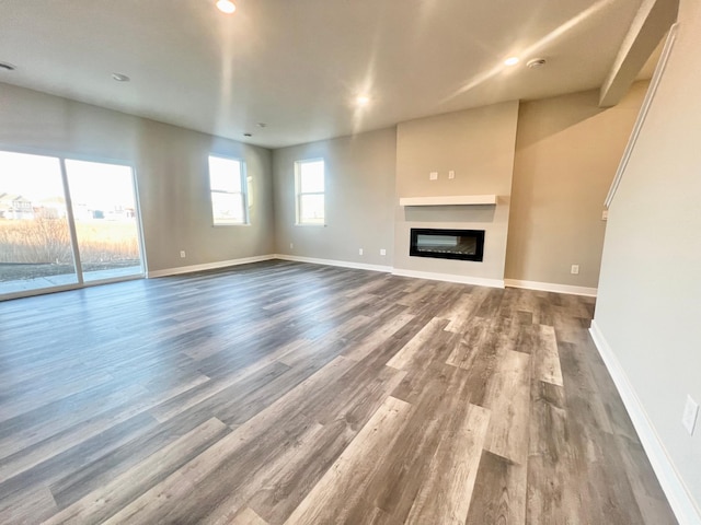 1025 Shoreview Dr, Jordan, MN 55352 - unfurnished living room with dark wood finished floors, baseboards, a glass covered fireplace, and recessed lighting