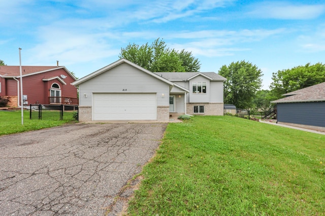 810 7th Ave N, Sauk Rapids, MN 56379 - tri-level home with brick siding, asphalt driveway, a garage, and a front yard