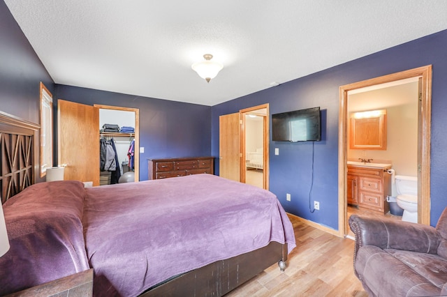 810 7th Ave N, Sauk Rapids, MN 56379 - bedroom with wood finished floors, connected bathroom, a spacious closet, baseboards, and a closet