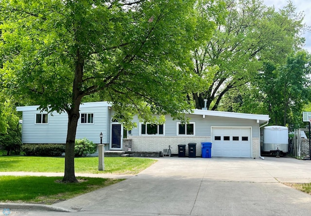902 18th Ave S, Fargo, ND 58103 - view of front of home featuring a garage, a front yard, driveway, and brick siding