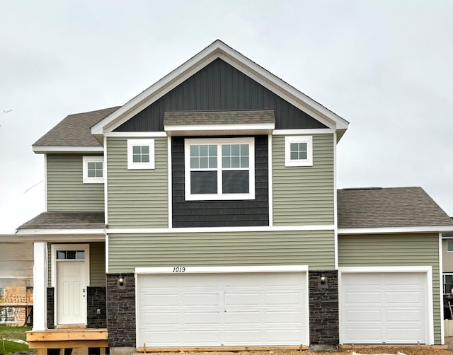 1019 Shoreview Dr, Jordan, MN 55352 - craftsman-style home with stone siding, an attached garage, and roof with shingles