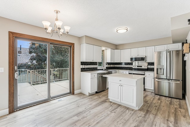 6535 Dawn Way, Inver Grove Heights, MN 55076 - kitchen featuring stainless steel appliances, backsplash, a chandelier, light wood-type flooring, and a textured ceiling