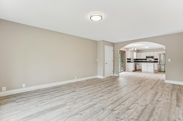 6535 Dawn Way, Inver Grove Heights, MN 55076 - unfurnished living room with arched walkways, a chandelier, and light wood-style floors