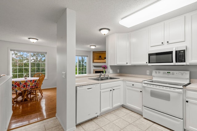 16047 72nd St NE, Otsego, MN 55330 - kitchen with white appliances, a textured ceiling, light countertops, white cabinets, and a sink
