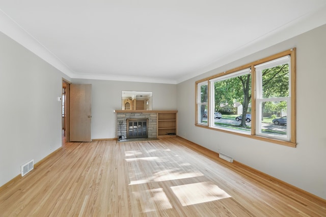 5652 Thomas Ave S, Minneapolis, MN 55410 - unfurnished living room featuring wood finished floors, a stone fireplace, baseboards, and ornamental molding