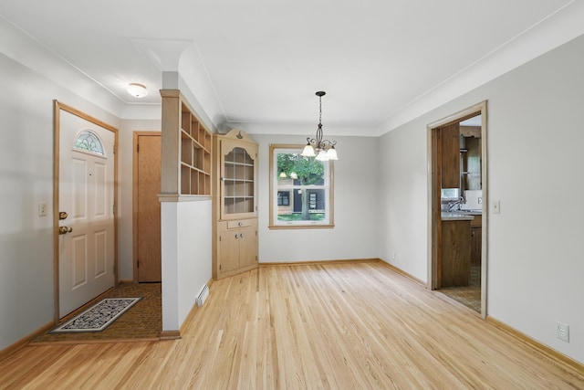 5652 Thomas Ave S, Minneapolis, MN 55410 - foyer entrance with light wood-style flooring, a chandelier, ornamental molding, and baseboards