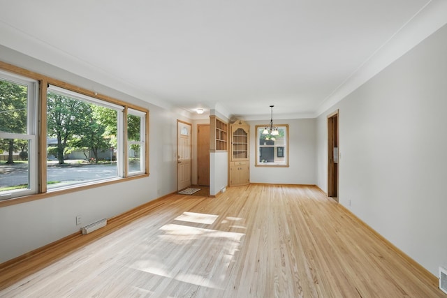 5652 Thomas Ave S, Minneapolis, MN 55410 - unfurnished living room featuring a chandelier, light wood finished floors, healthy amount of natural light, crown molding, and baseboards