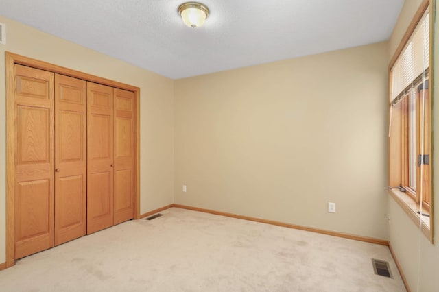 16976 81st Ave N, Maple Grove, MN 55311 - unfurnished bedroom with light colored carpet, baseboards, and a closet