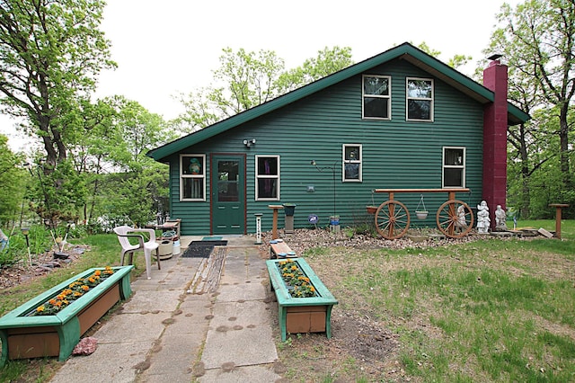 39817 Osage Dr, Browerville, MN 56438 - rear view of property with a chimney, a vegetable garden, a yard, and a patio area